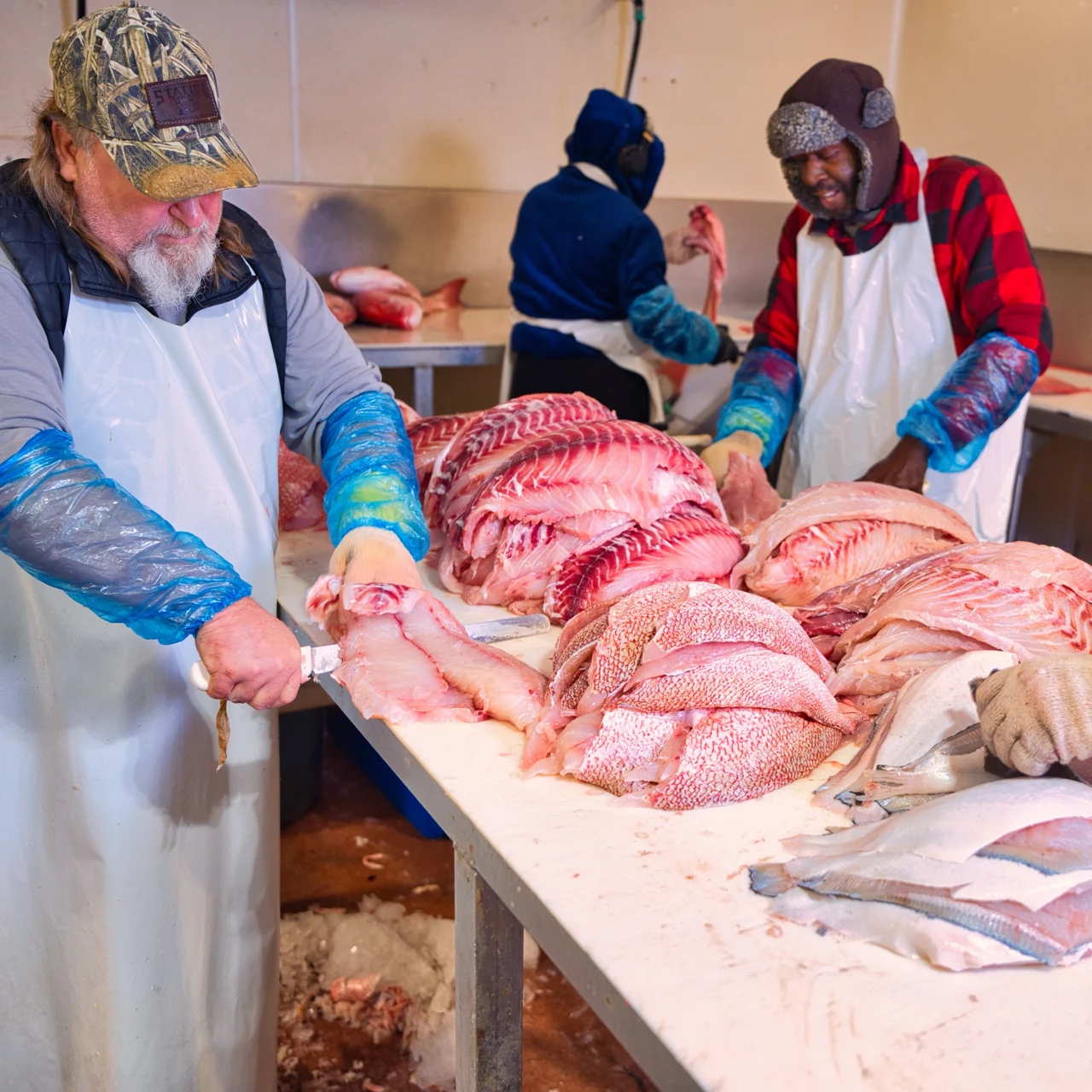 Water Street employees cutting and preparing fish in the processing facility
